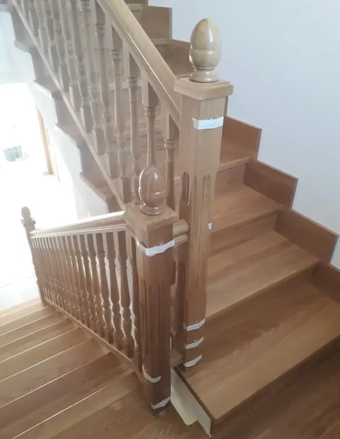 Escalera de madera con barandilla torneada y remate esférico