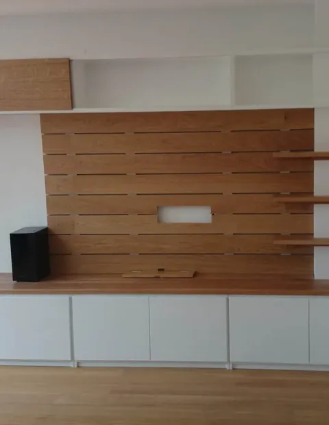 Mueble bajo con panel de listones de madera para el televisor