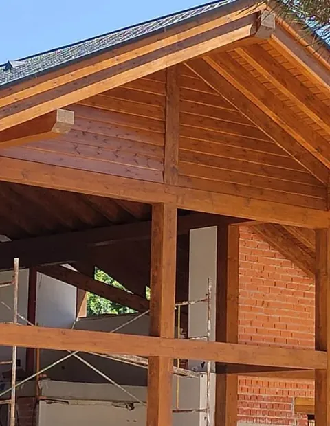 Estructura de cubierta de madera montada sobre un muro de ladrillo