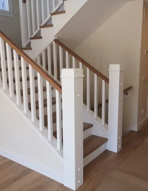 Escalera con barandilla blanca y peldaños de madera