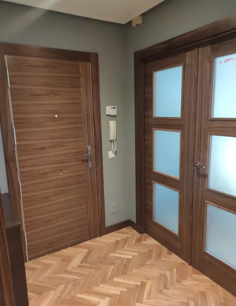 Puerta de entrada de madera y puertas correderas acristaladas