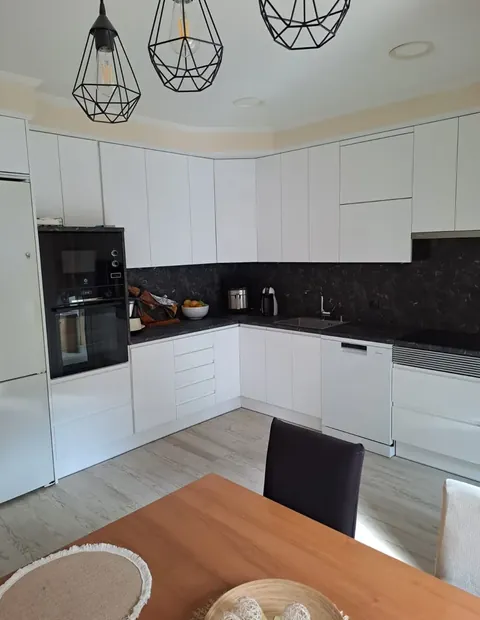Cocina blanca en L con encimera oscura